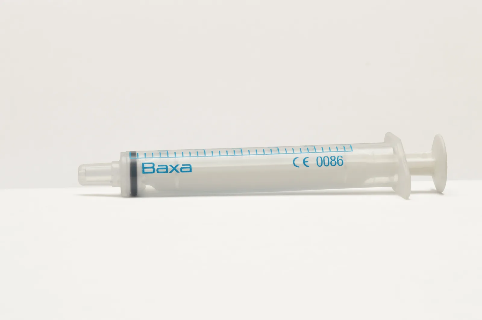 A medical professional in a clean clinic prepares a syringe for a cosmetic injectable procedure.